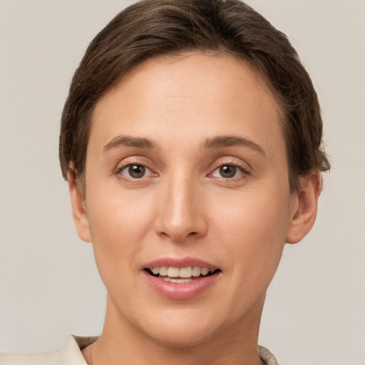 Joyful white young-adult female with short  brown hair and grey eyes