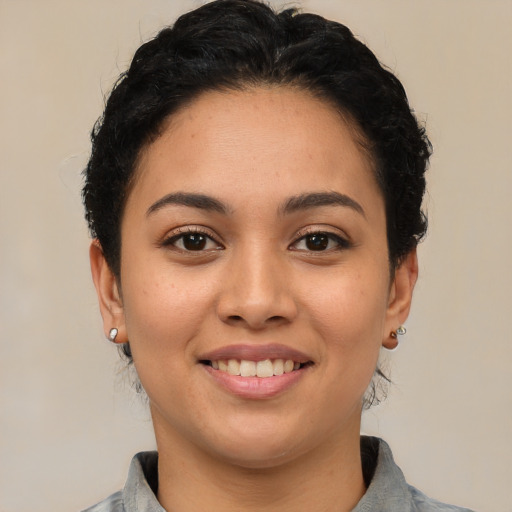 Joyful latino young-adult female with short  brown hair and brown eyes