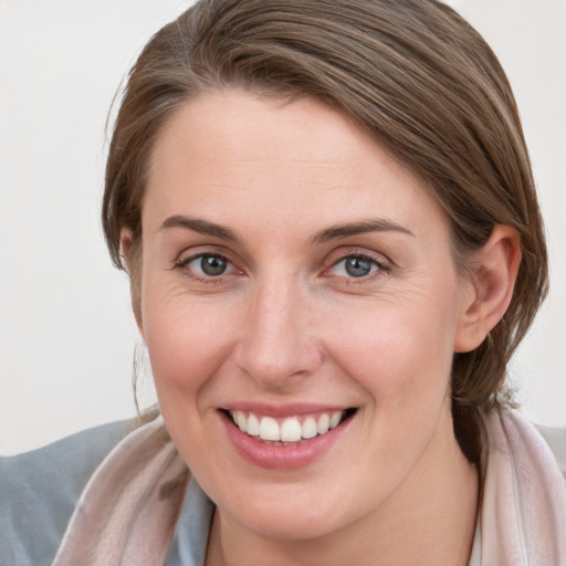 Joyful white young-adult female with long  brown hair and blue eyes