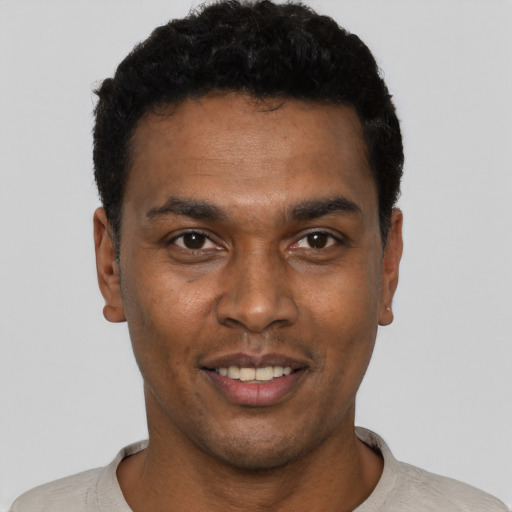 Joyful black young-adult male with short  black hair and brown eyes