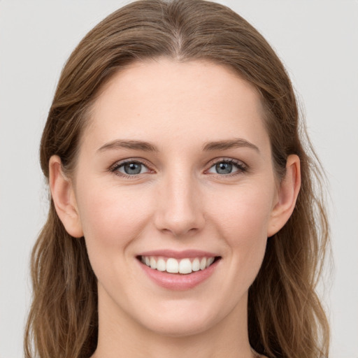 Joyful white young-adult female with long  brown hair and grey eyes