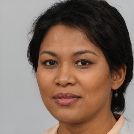 Joyful latino adult female with medium  brown hair and brown eyes
