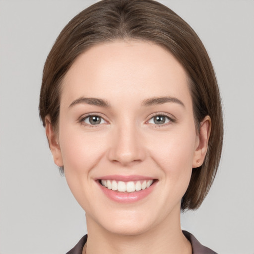 Joyful white young-adult female with medium  brown hair and grey eyes