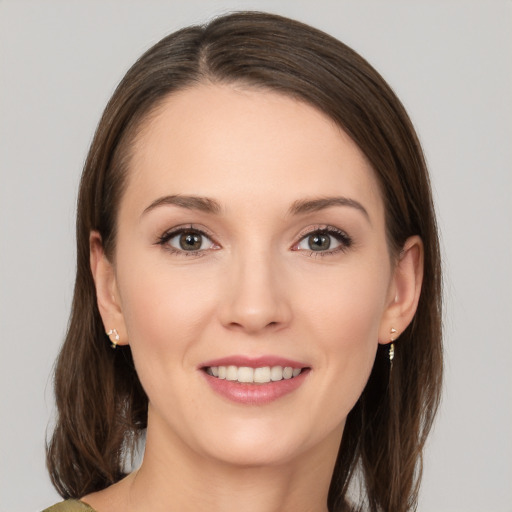 Joyful white young-adult female with medium  brown hair and green eyes