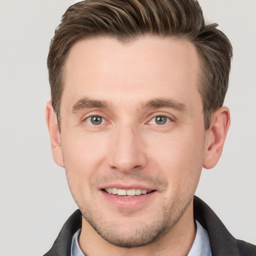 Joyful white young-adult male with short  brown hair and grey eyes