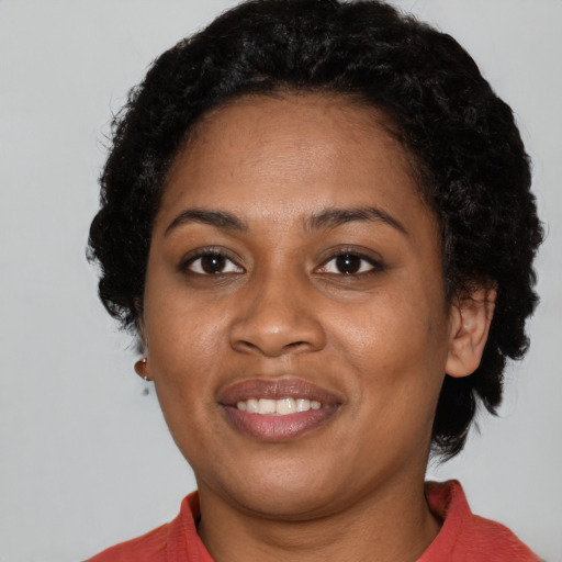 Joyful black young-adult female with short  black hair and brown eyes