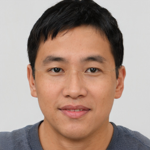 Joyful asian young-adult male with short  black hair and brown eyes