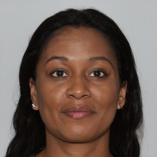Joyful black adult female with long  brown hair and brown eyes