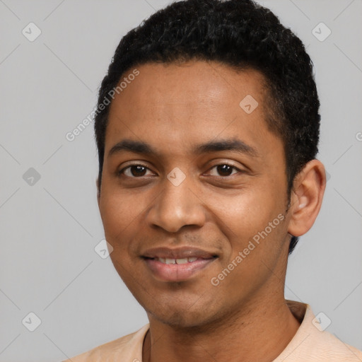 Joyful black young-adult male with short  black hair and brown eyes