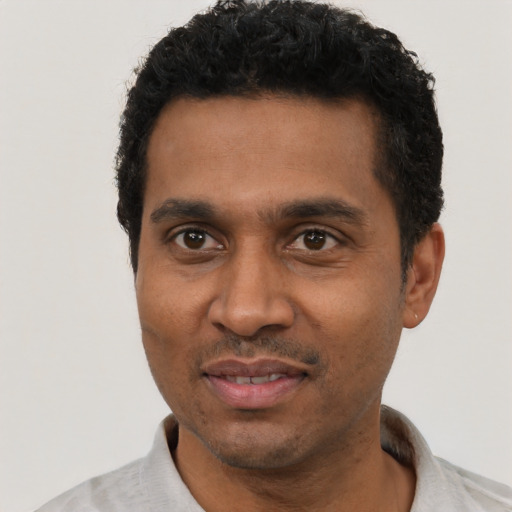 Joyful black adult male with short  black hair and brown eyes