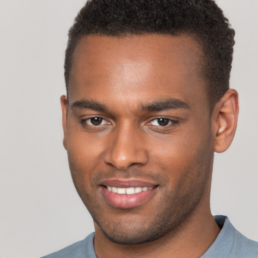 Joyful black young-adult male with short  brown hair and brown eyes