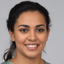 Joyful latino young-adult female with medium  brown hair and brown eyes