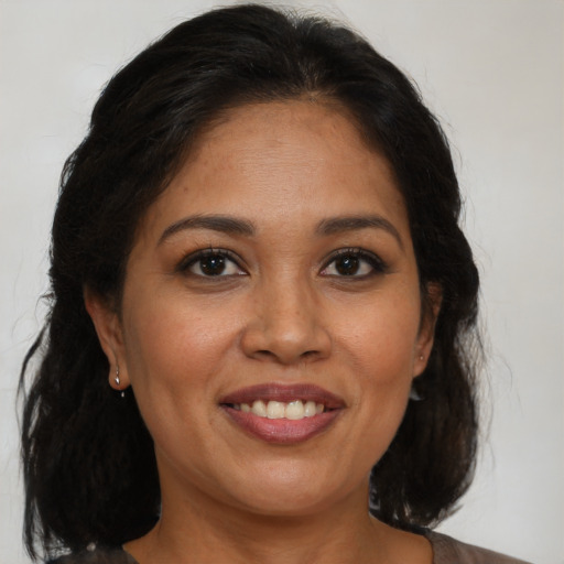 Joyful latino adult female with medium  brown hair and brown eyes