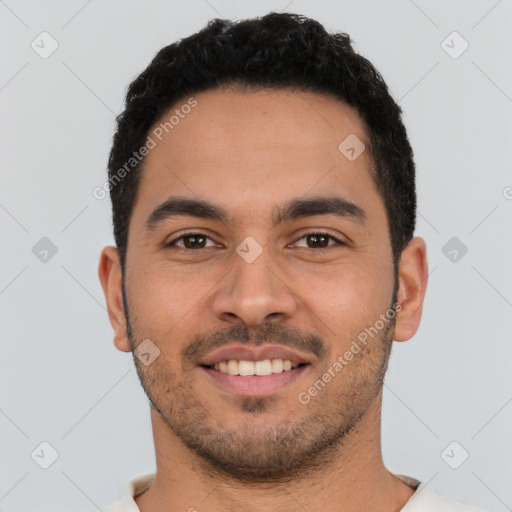 Joyful latino young-adult male with short  black hair and brown eyes