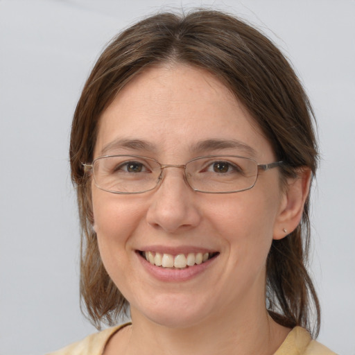 Joyful white adult female with medium  brown hair and blue eyes