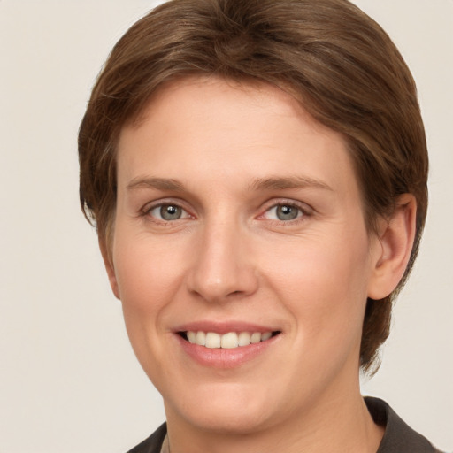 Joyful white young-adult female with medium  brown hair and grey eyes