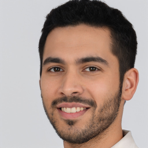 Joyful latino young-adult male with short  black hair and brown eyes