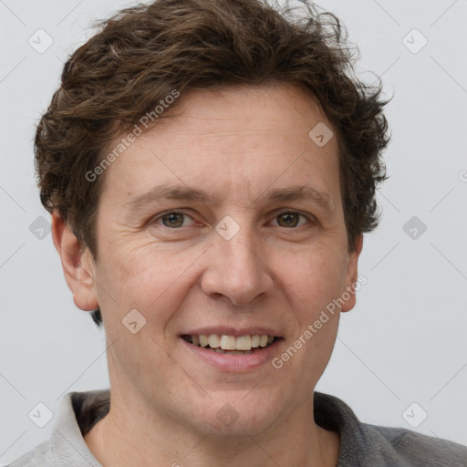 Joyful white adult male with short  brown hair and grey eyes