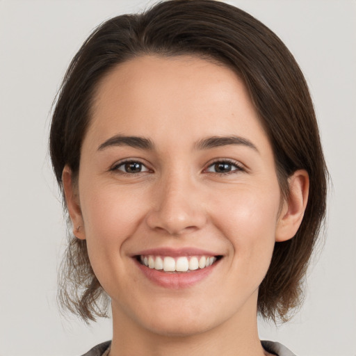 Joyful white young-adult female with medium  brown hair and brown eyes