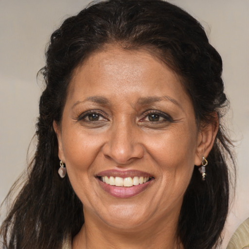 Joyful black adult female with long  brown hair and brown eyes