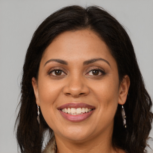 Joyful latino adult female with long  brown hair and brown eyes