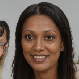 Joyful black adult female with long  brown hair and brown eyes