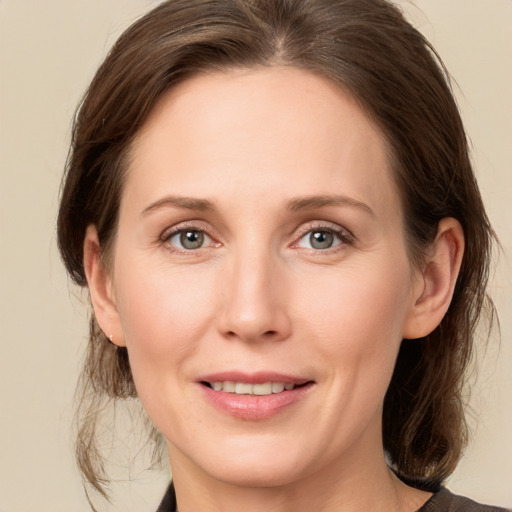 Joyful white young-adult female with medium  brown hair and grey eyes