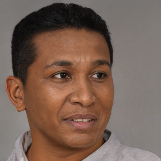 Joyful black adult male with short  brown hair and brown eyes