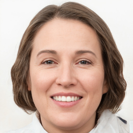 Joyful white young-adult female with medium  brown hair and green eyes