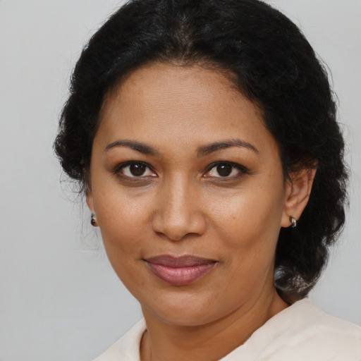 Joyful black adult female with short  brown hair and brown eyes