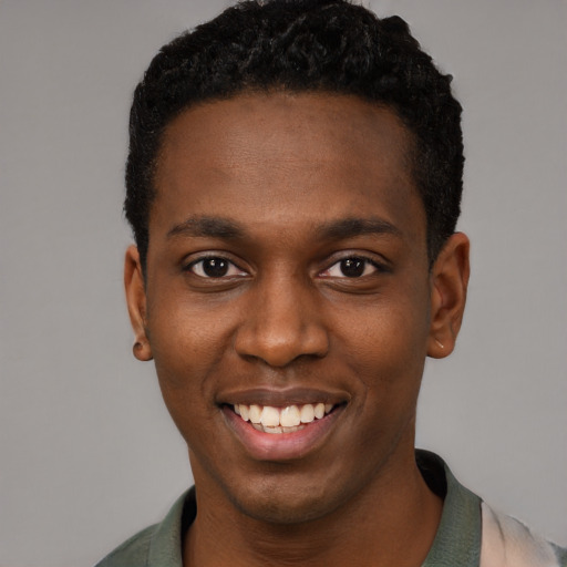 Joyful black young-adult male with short  black hair and brown eyes