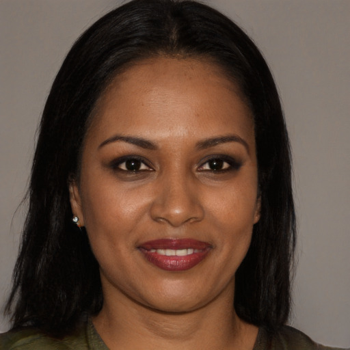 Joyful black young-adult female with long  brown hair and brown eyes