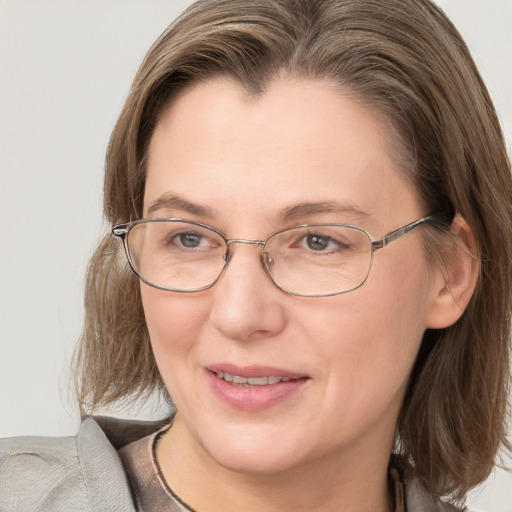 Joyful white adult female with medium  brown hair and grey eyes