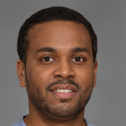 Joyful latino young-adult male with short  brown hair and brown eyes