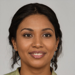 Joyful latino young-adult female with medium  brown hair and brown eyes