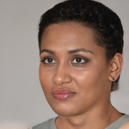 Joyful black young-adult female with short  black hair and brown eyes