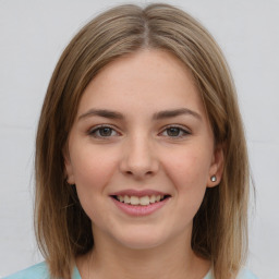 Joyful white young-adult female with medium  brown hair and grey eyes