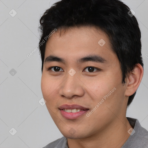 Joyful asian young-adult male with short  black hair and brown eyes