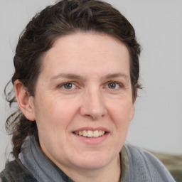 Joyful white adult female with medium  brown hair and grey eyes