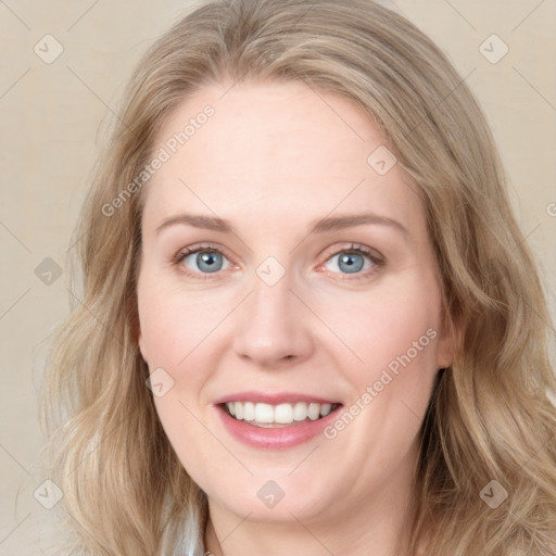 Joyful white young-adult female with long  brown hair and blue eyes