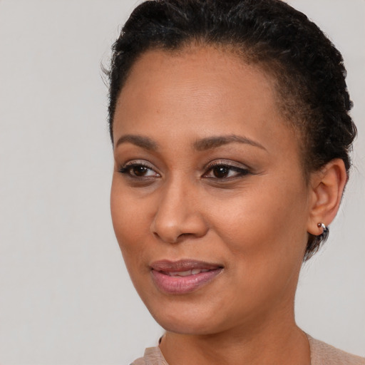 Joyful black young-adult female with short  brown hair and brown eyes