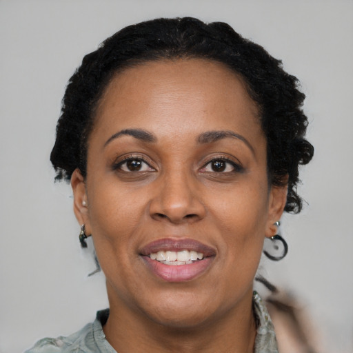Joyful black adult female with short  brown hair and brown eyes