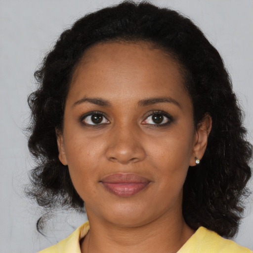 Joyful black young-adult female with medium  brown hair and brown eyes