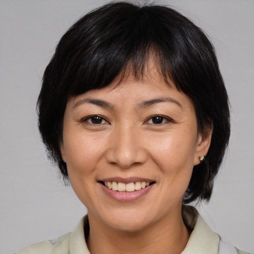 Joyful asian adult female with medium  brown hair and brown eyes