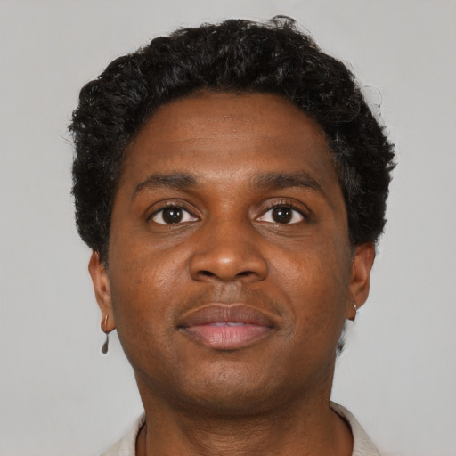 Joyful black young-adult male with short  brown hair and brown eyes