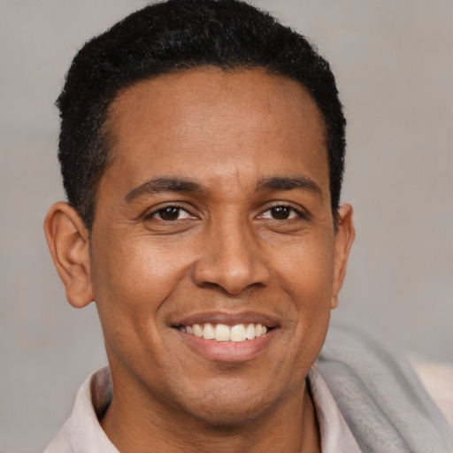 Joyful latino adult male with short  brown hair and brown eyes