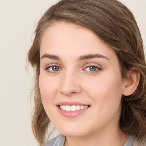 Joyful white young-adult female with medium  brown hair and green eyes