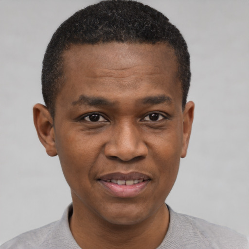 Joyful black young-adult male with short  black hair and brown eyes