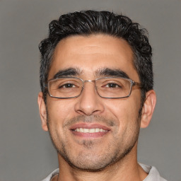 Joyful white adult male with short  black hair and brown eyes