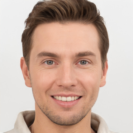 Joyful white young-adult male with short  brown hair and grey eyes